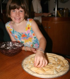 Abby lays apple slices on the pizza