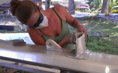Amanda using a grinder & polishing pad to touch up the mast