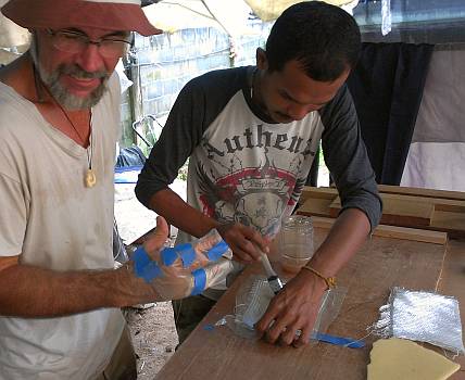 Dr. Baw wetting out the glass with polyester, on a sheet of polyethylene