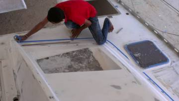 Baw masking the starboard foredeck with blue-tape