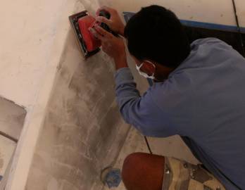 Beng sanding in front of the salon (wall was cut open)