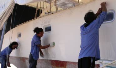 Chai, Jack, & Lek wet-sanding the starboard topsides with 360