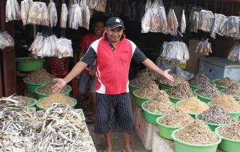 Fish vendor shows off dried fish, Kupang