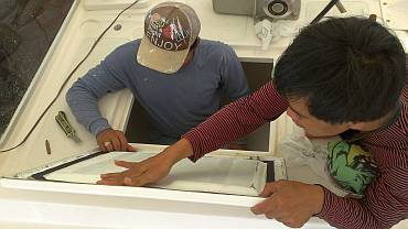 Heru and Yando putting new gasket on the chain locker hatch