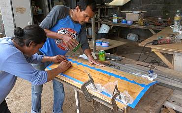 Baw helping Houa epoxy teak veneer to a rounded backing