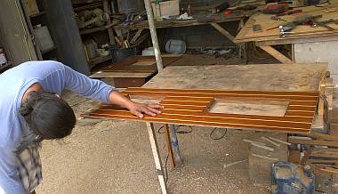 Houa checking a floorboard with some delaminating plywood