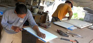 Houa shaping cabinet formica while Jon grinds hatch fiberglass