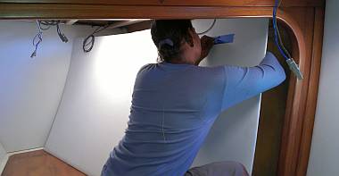 Houa fishing a wire through a headliner in a forward cabin