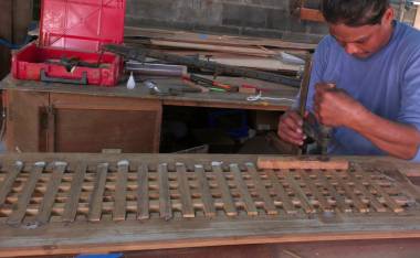 Houa pressing the new teak lattice into its frame