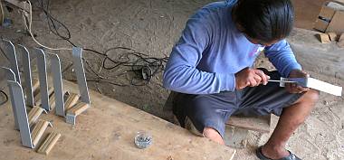 Houa screwing the teak foot-pads onto the mast steps