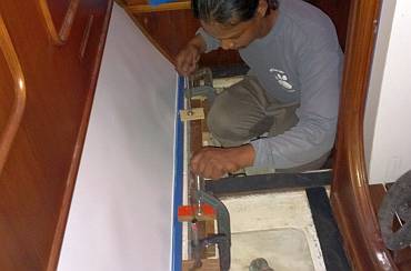 Mounting the teak floor-strip beside the white formica