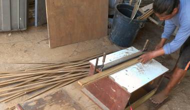 Houa using his makeshift table saw to cut teak strips