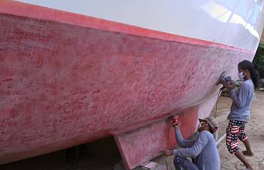 Heru and Chandron almost finished sanding the starboard hull