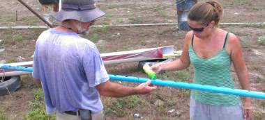 Amanda lubing the slot in the PVC mast conduit with detergent