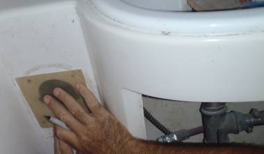 Jon measuring a small sheet of glass to mount mixing valves