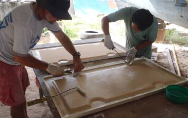Jon & Boy laying the final sheets of biaxial glass over the foam