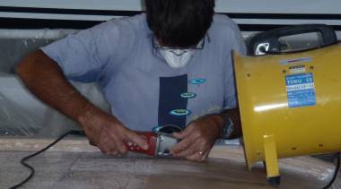 Jon using a sander/grinder in front of a big blower to trim glass