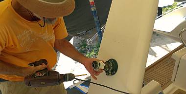 Jon's hat mounting the dinghy hoist winch that Heru serviced