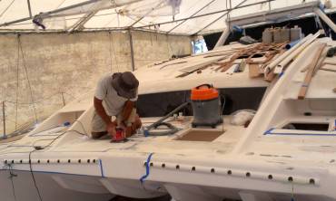 Jon sanding where the nonskid will go, on Ocelot's foredeck