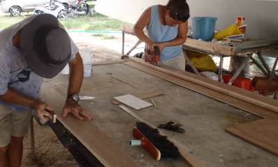 Amanda cutting frames with a jig-saw while Jon trims & smoothes them