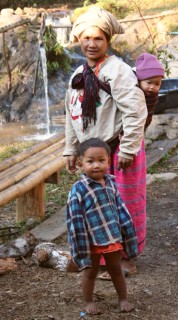 Villagers in the Karen village. Behind is the "shower" for trekkers.