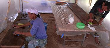 Lek and Baw wet-sanding the cockpit table in the spray-tent