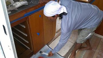 Lek stripping old varnish off the galley peninsula doors