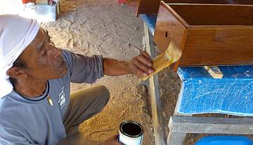 Lek brushing another coat of gloss varnish on a drawer face