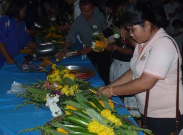 Folks buying bouquets, incense, & candles for the procession