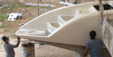 Pla working on the transom, Lek on the aft topsides