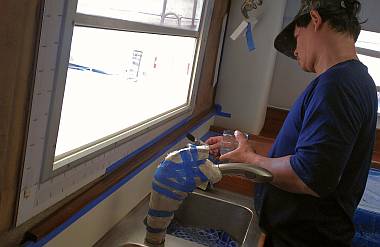 Pla brushing polyurethane on teak in the galley