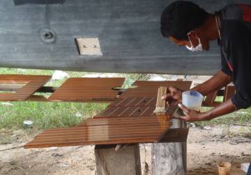 Floorboard getting their first coats of polyurethane varnish