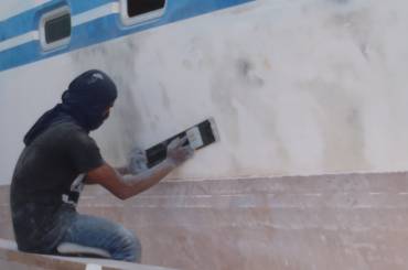 Long-Boarding Ocelot's topsides, sanding off the black paint