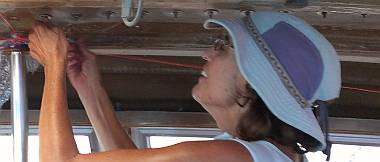 Sue tightening sail-track nuts in the roof of Ocelot's salon