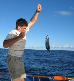 Jon pulls in a tuna. No help from Amanda with the fish, now!