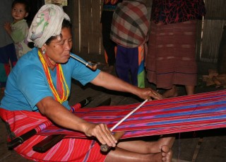 A Karen woman weaves in the hilltribe village