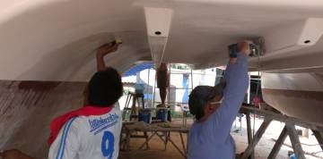 Yoong and Pla sanding difficult bits under the bridge-deck